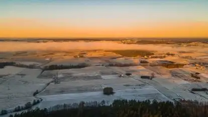 Pierwszy śnieg i wschód słońca nad jeziorem Boczne