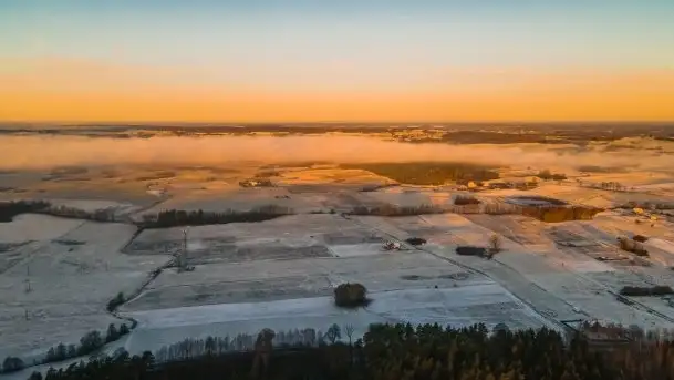 Pierwszy śnieg i wschód słońca nad jeziorem Boczne